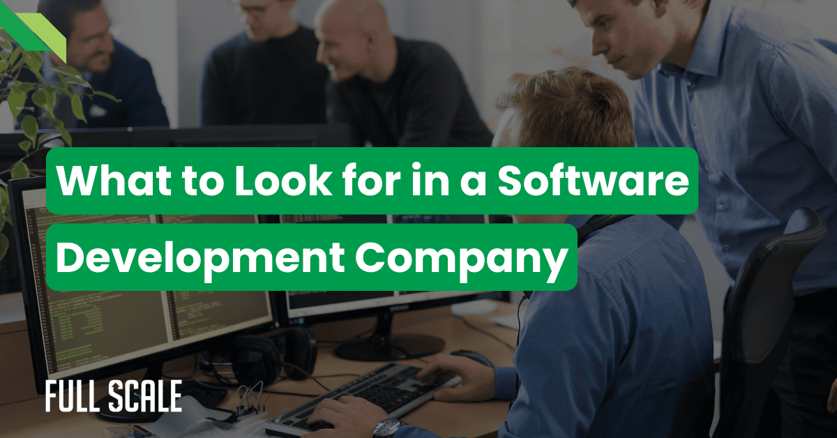 Four people collaborate at computers in an office. Overlaid text reads: "What to Look for in a Custom Software Development Company." The Full Scale logo appears in the corner.