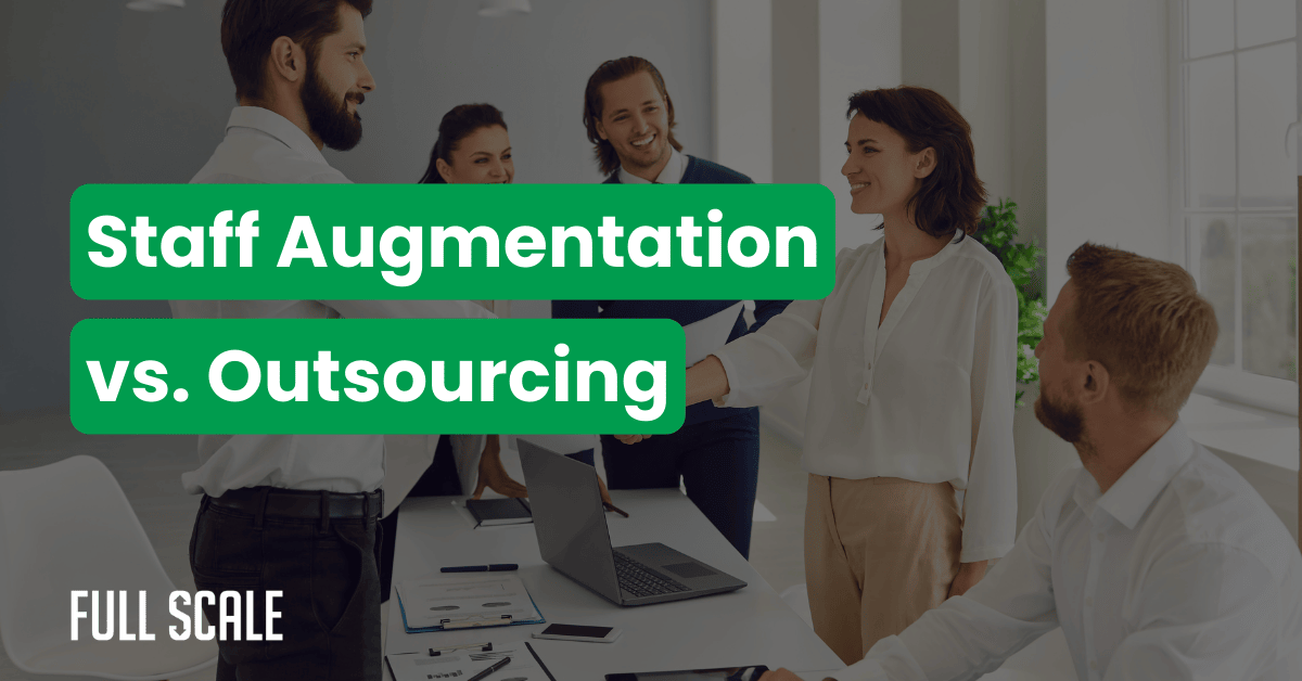 Four professionals in an office handshake across a table, with the text "Staff Augmentation vs. Outsourcing" prominently displayed—perfect for illustrating staff augmentation vs. project outsourcing or managed services discussions. Laptop and documents are on the table.