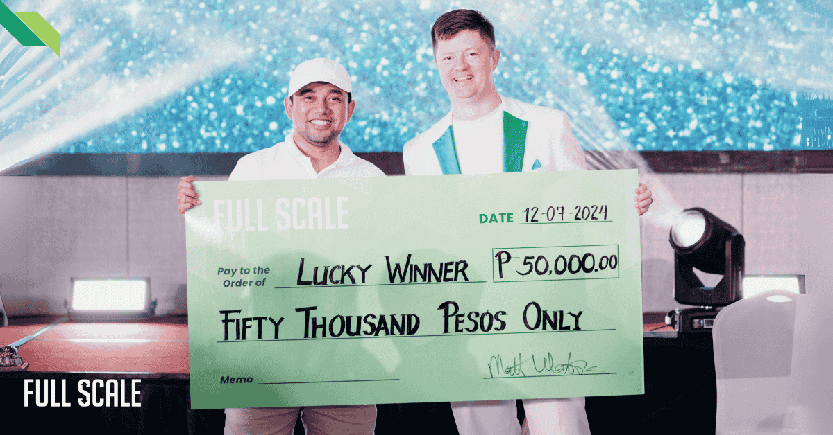 Two men smiling and holding a large check for fifty thousand pesos at a presentation event.